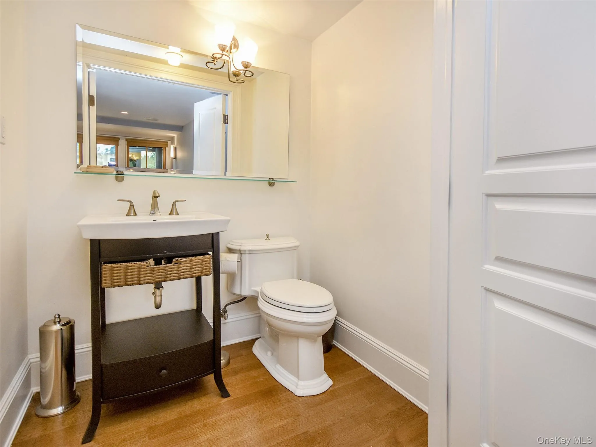 Bathroom with vanity, light wood-type flooring, and a chandelier Bathroom with vanity, light wood-type flooring, and a chandelier
