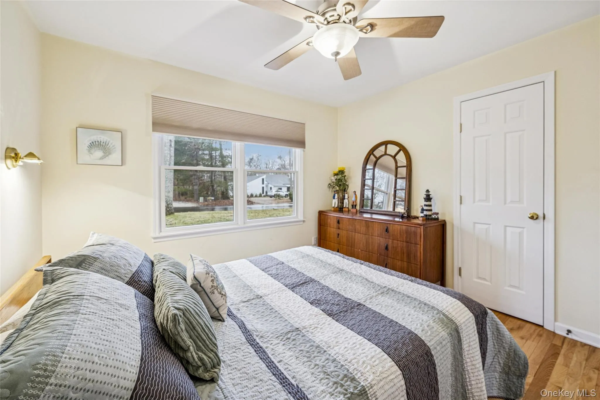 Bedroom with light wood-style floors, multiple windows, and ceiling fan Bedroom with light wood-style floors, multiple windows, and ceiling fan