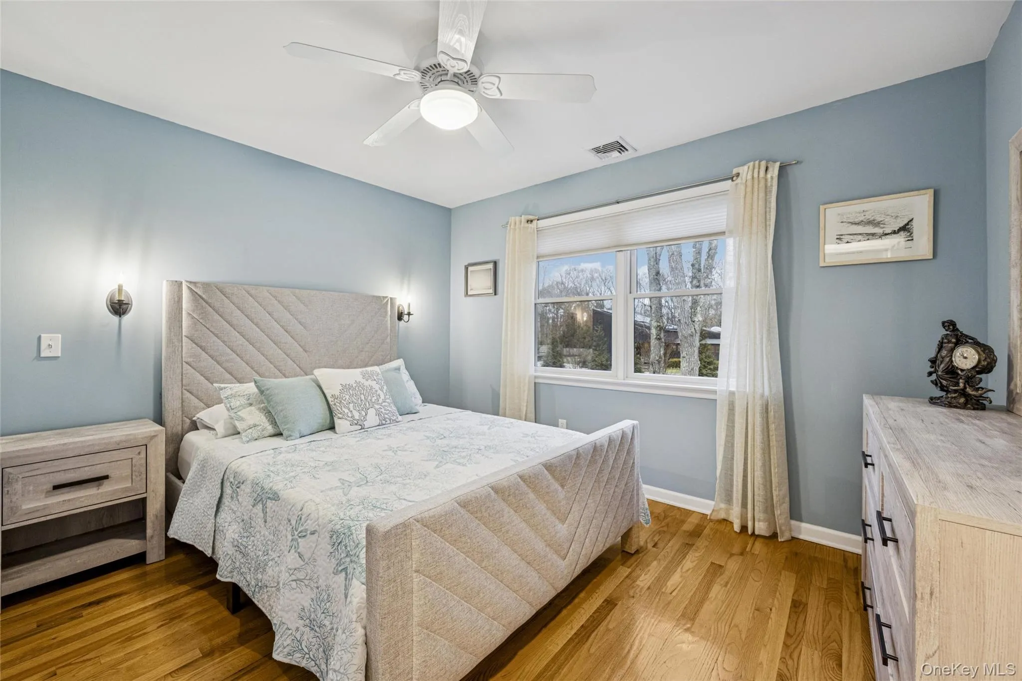 Bedroom with light wood-style floors and ceiling fan Bedroom with light wood-style floors and ceiling fan