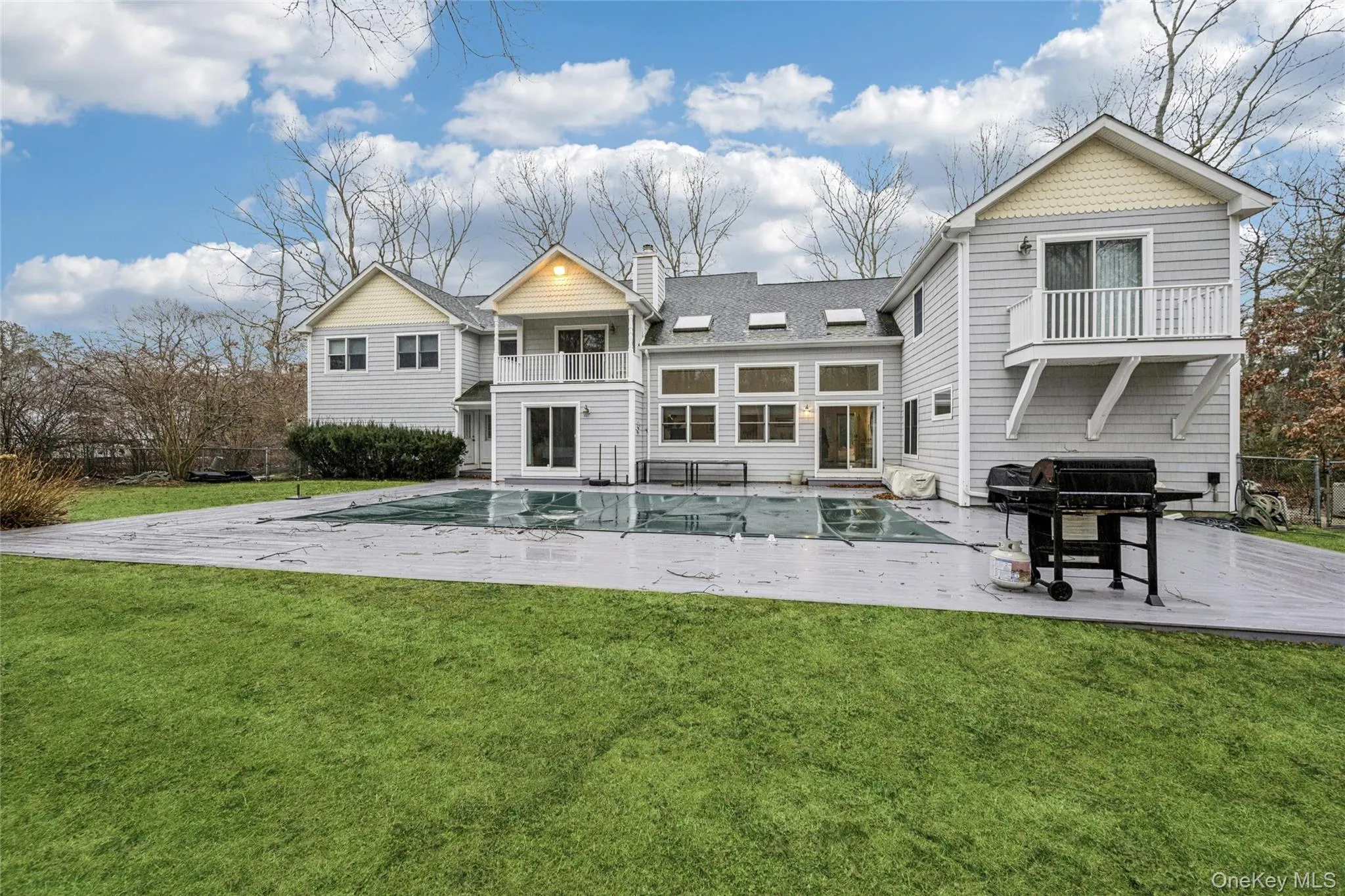 Rear view of house with a yard, a balcony, a patio area, and a chimney Rear view of house with a yard, a balcony, a patio area, and a chimney