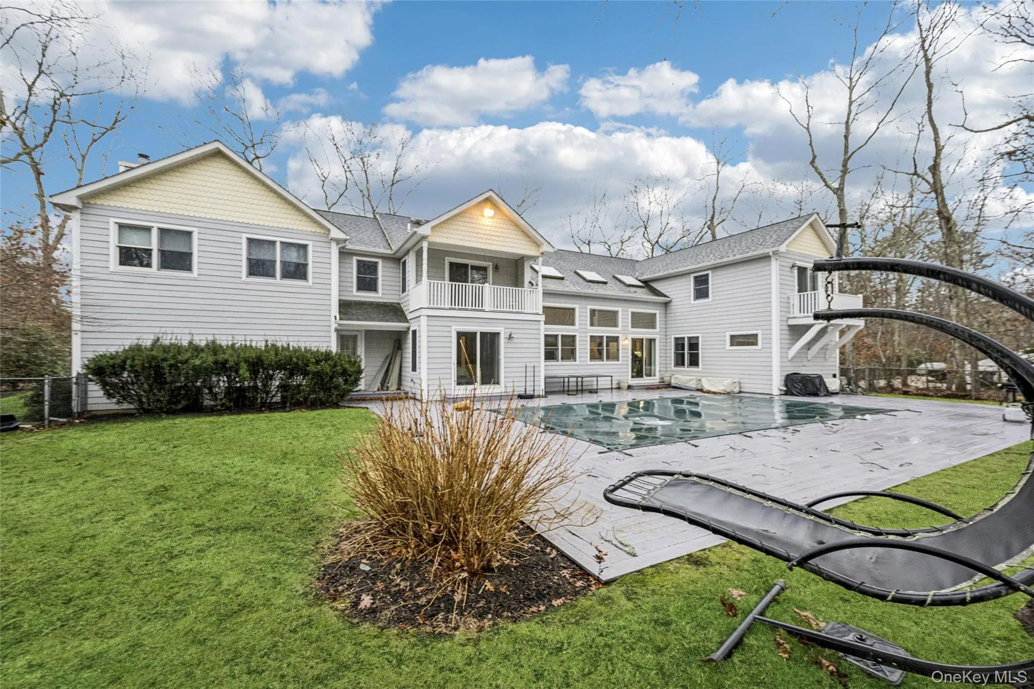 Rear view of house featuring a balcony, a patio area, and roof with shingles Rear view of house featuring a balcony, a patio area, and roof with shingles