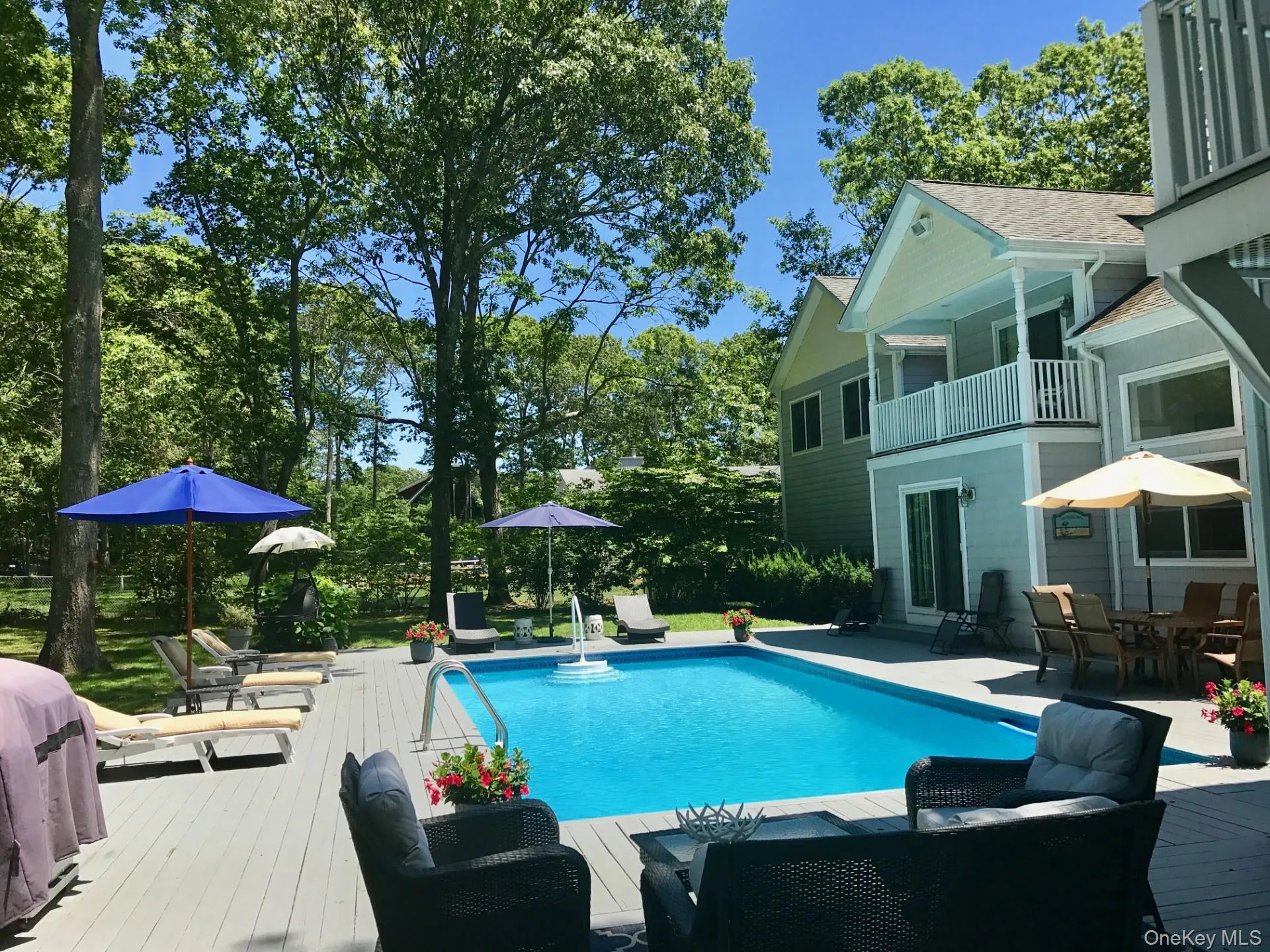 Swimming pool featuring outdoor dining area, a balcony, area for grilling, a patio, and view of wooded area Swimming pool featuring outdoor dining area, a balcony, area for grilling, a patio, and view of wooded area