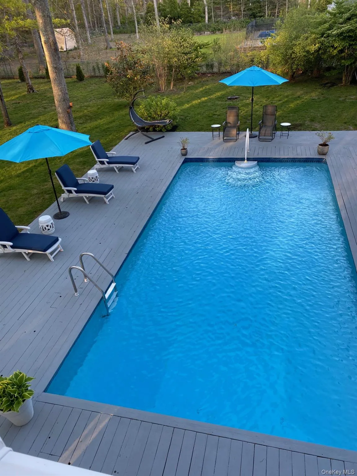 Outdoor pool featuring a yard and a deck Outdoor pool featuring a yard and a deck