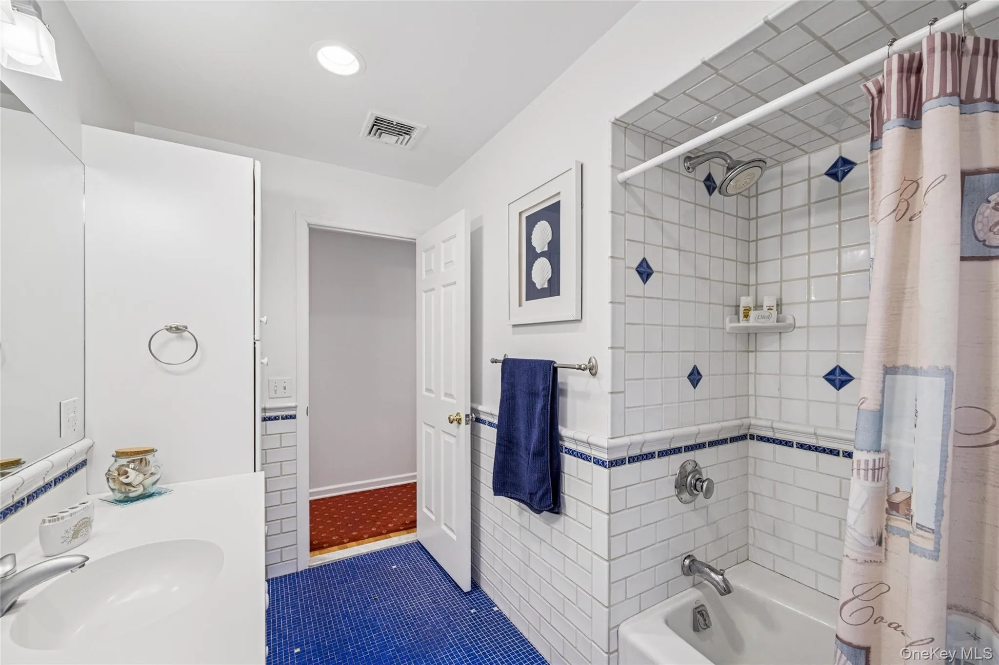 Full bath featuring shower / tub combo with curtain, vanity, dark tile patterned flooring, and recessed lighting Full bath featuring shower / tub combo with curtain, vanity, dark tile patterned flooring, and recessed lighting