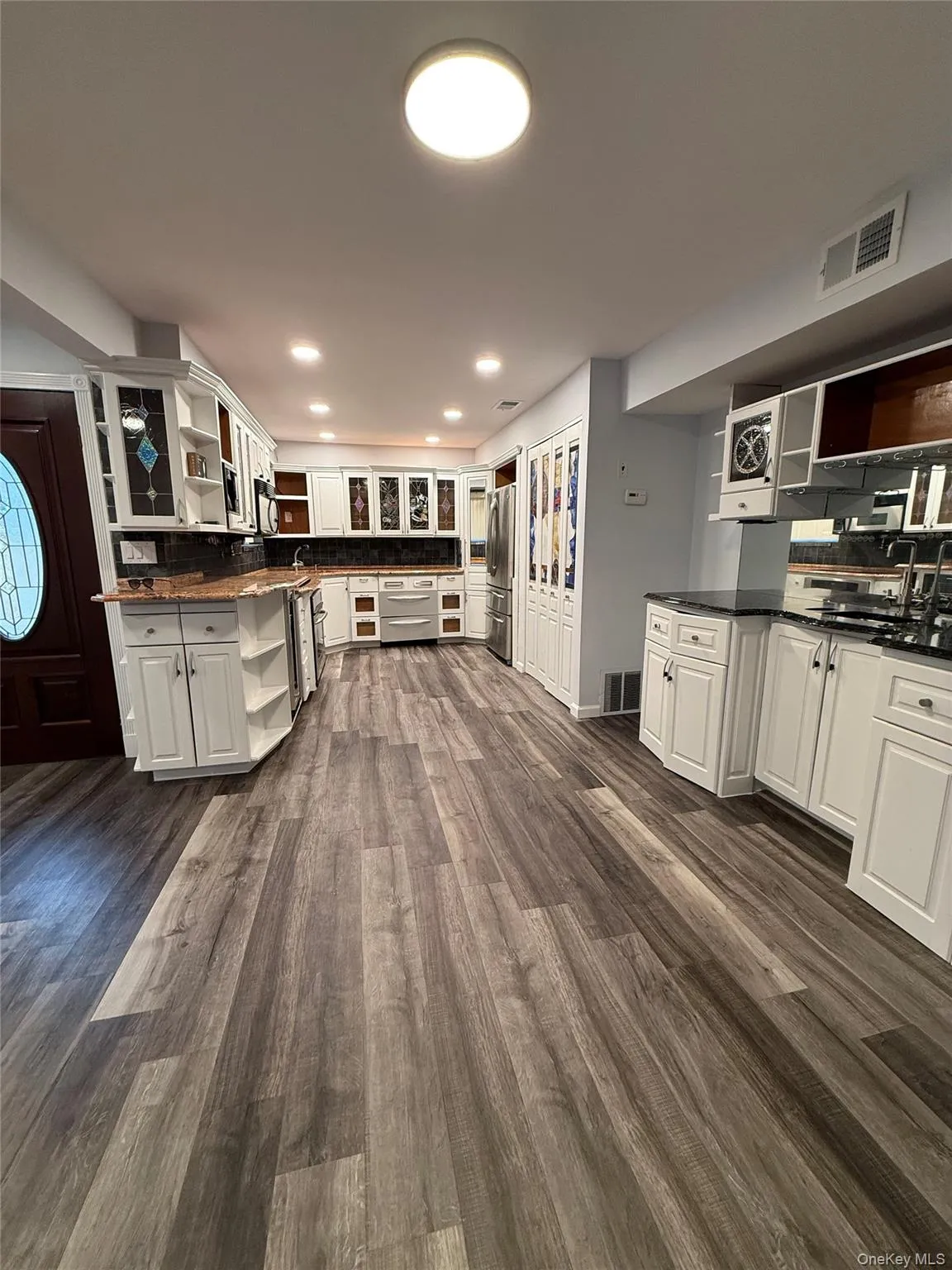 Kitchen with open shelves, white cabinets, and dark wood finished floors Kitchen with open shelves, white cabinets, and dark wood finished floors