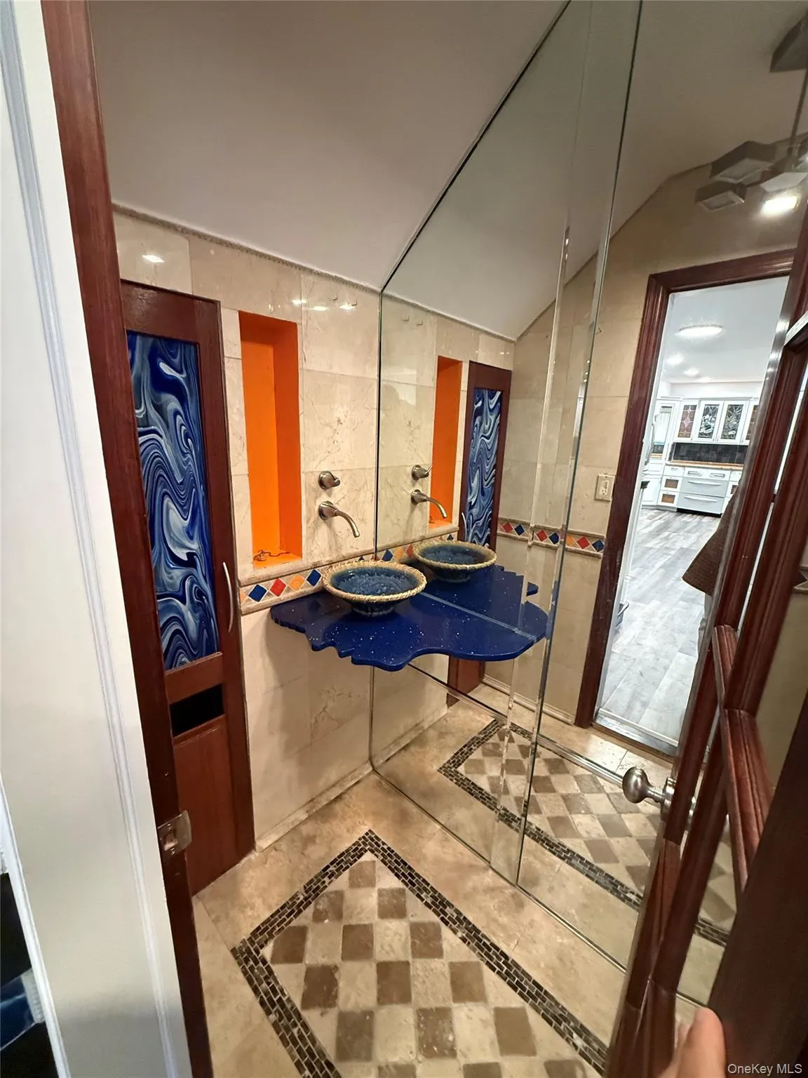 Hall featuring inlaid floor details, tile walls, lofted ceiling, and tile patterned floors Hall featuring inlaid floor details, tile walls, lofted ceiling, and tile patterned floors