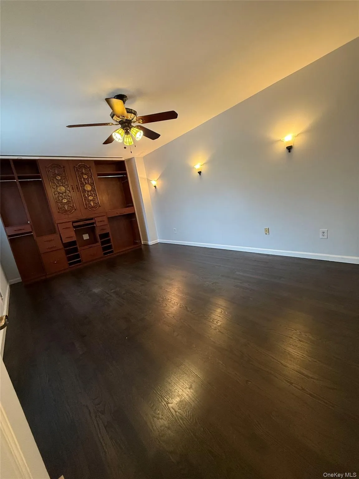 Unfurnished living room featuring dark wood finished floors and ceiling fan Unfurnished living room featuring dark wood finished floors and ceiling fan