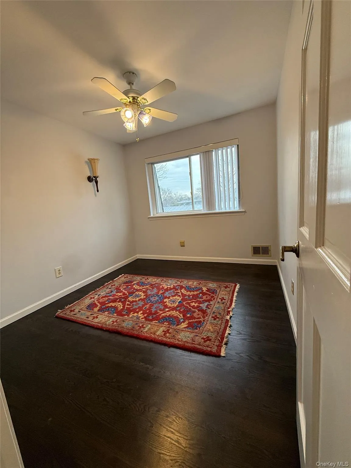 Spare room featuring dark wood-style floors and ceiling fan Spare room featuring dark wood-style floors and ceiling fan
