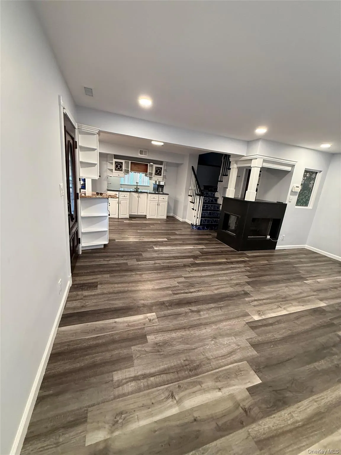 Living area featuring dark wood-style flooring, stairway, and recessed lighting Living area featuring dark wood-style flooring, stairway, and recessed lighting