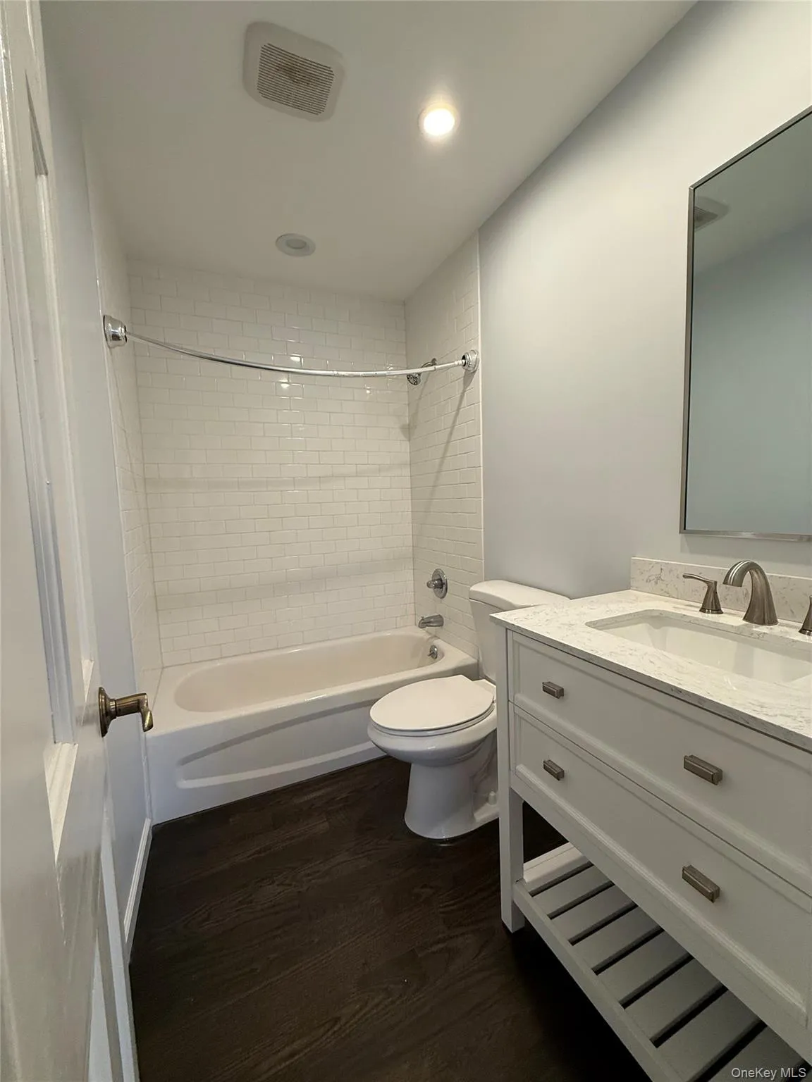 Full bathroom featuring vanity, dark wood-type flooring, shower / tub combination, and recessed lighting Full bathroom featuring vanity, dark wood-type flooring, shower / tub combination, and recessed lighting