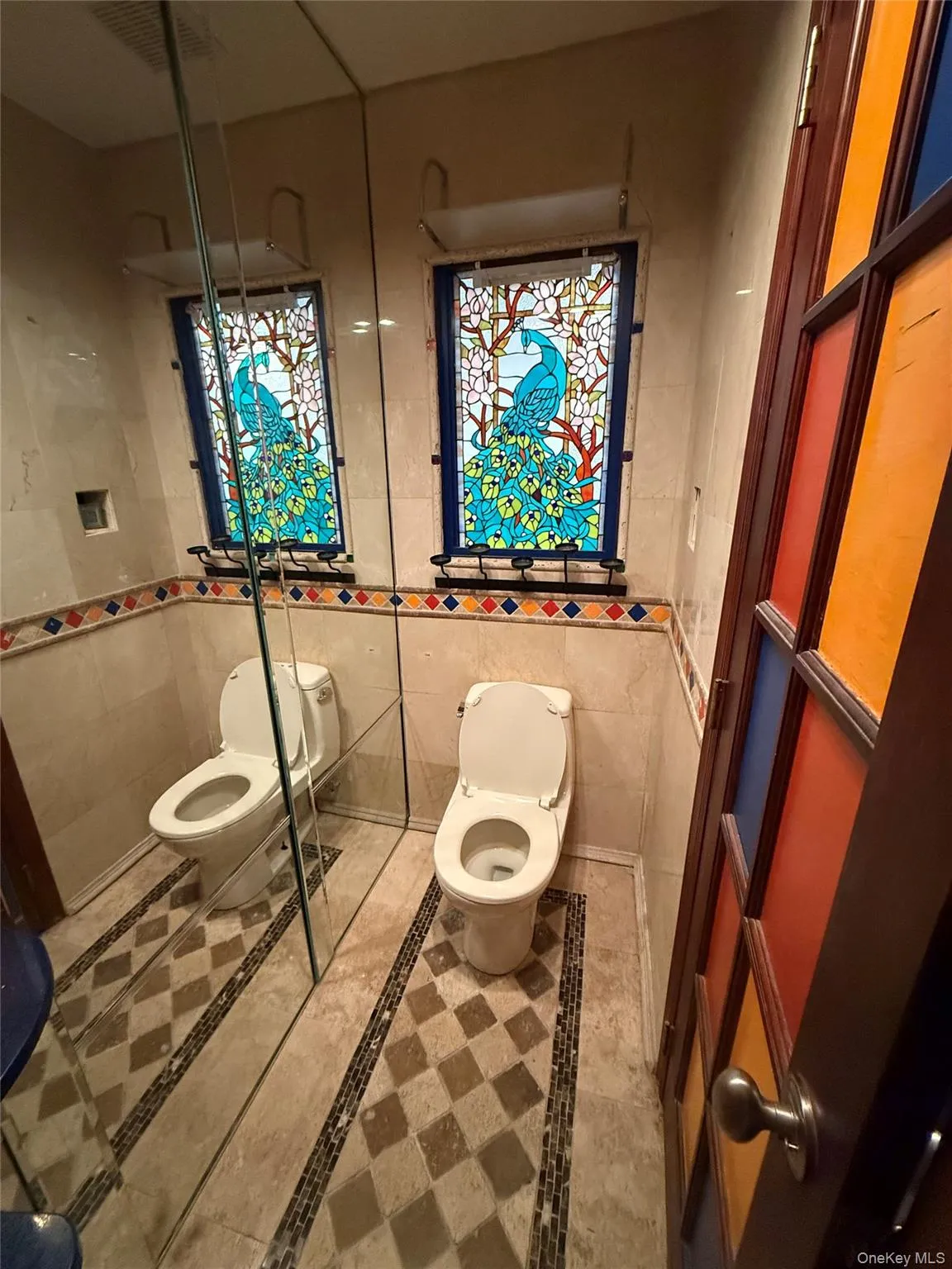 Full bathroom featuring inlaid floor details, tile walls, and tile patterned floors Full bathroom featuring inlaid floor details, tile walls, and tile patterned floors