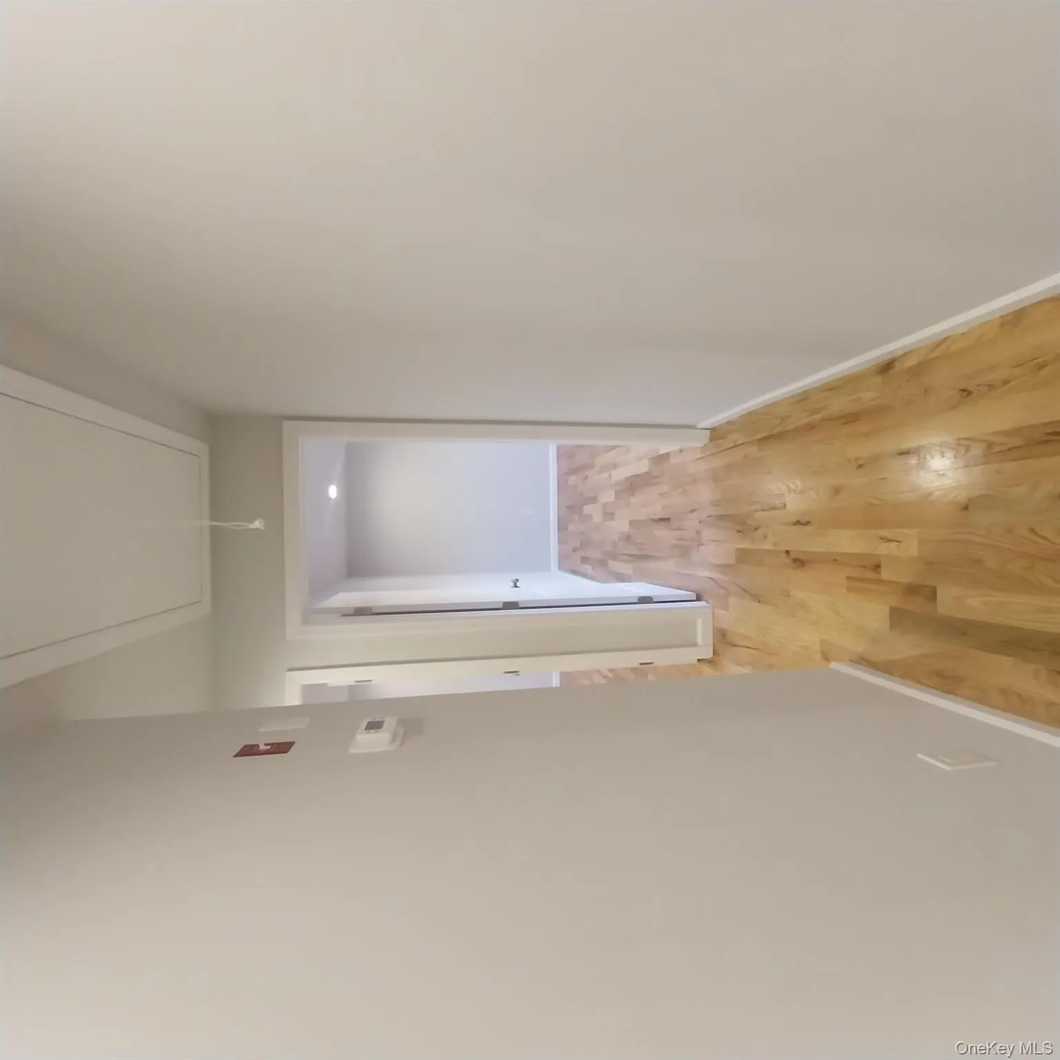 Corridor featuring attic access and light wood-style flooring Corridor featuring attic access and light wood-style flooring