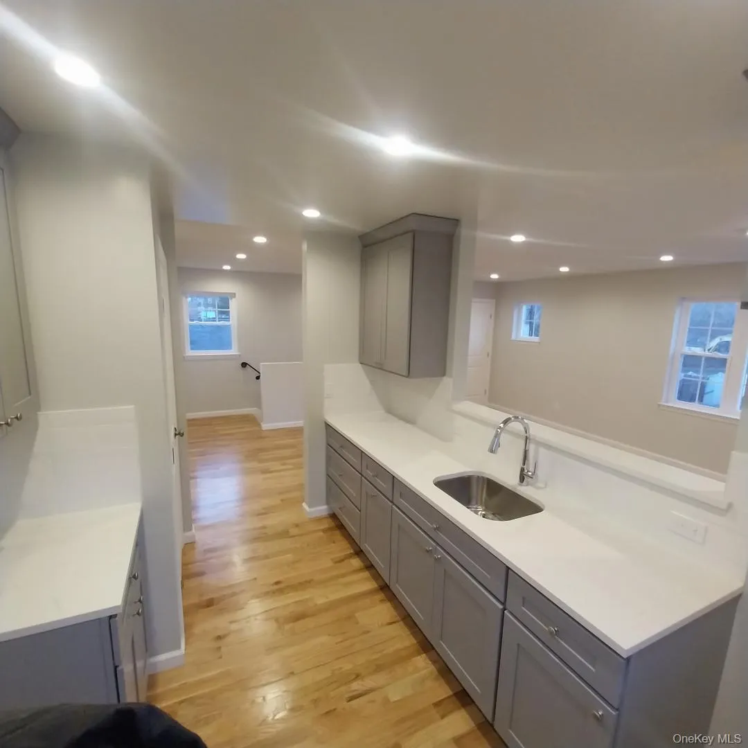 Kitchen featuring gray cabinets, light wood finished floors, light stone countertops, and recessed lighting Kitchen featuring gray cabinets, light wood finished floors, light stone countertops, and recessed lighting