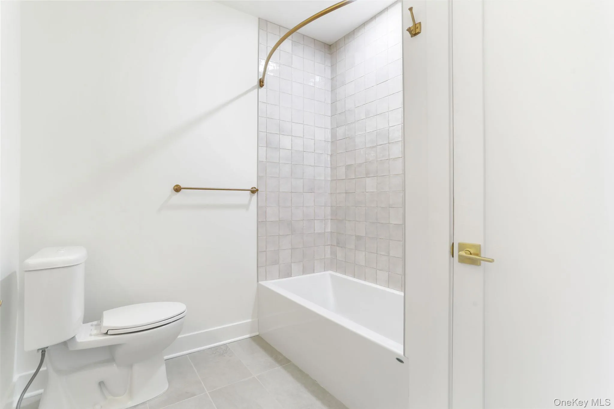 Full bath featuring light tile patterned flooring and shower / tub combination Full bath featuring light tile patterned flooring and shower / tub combination