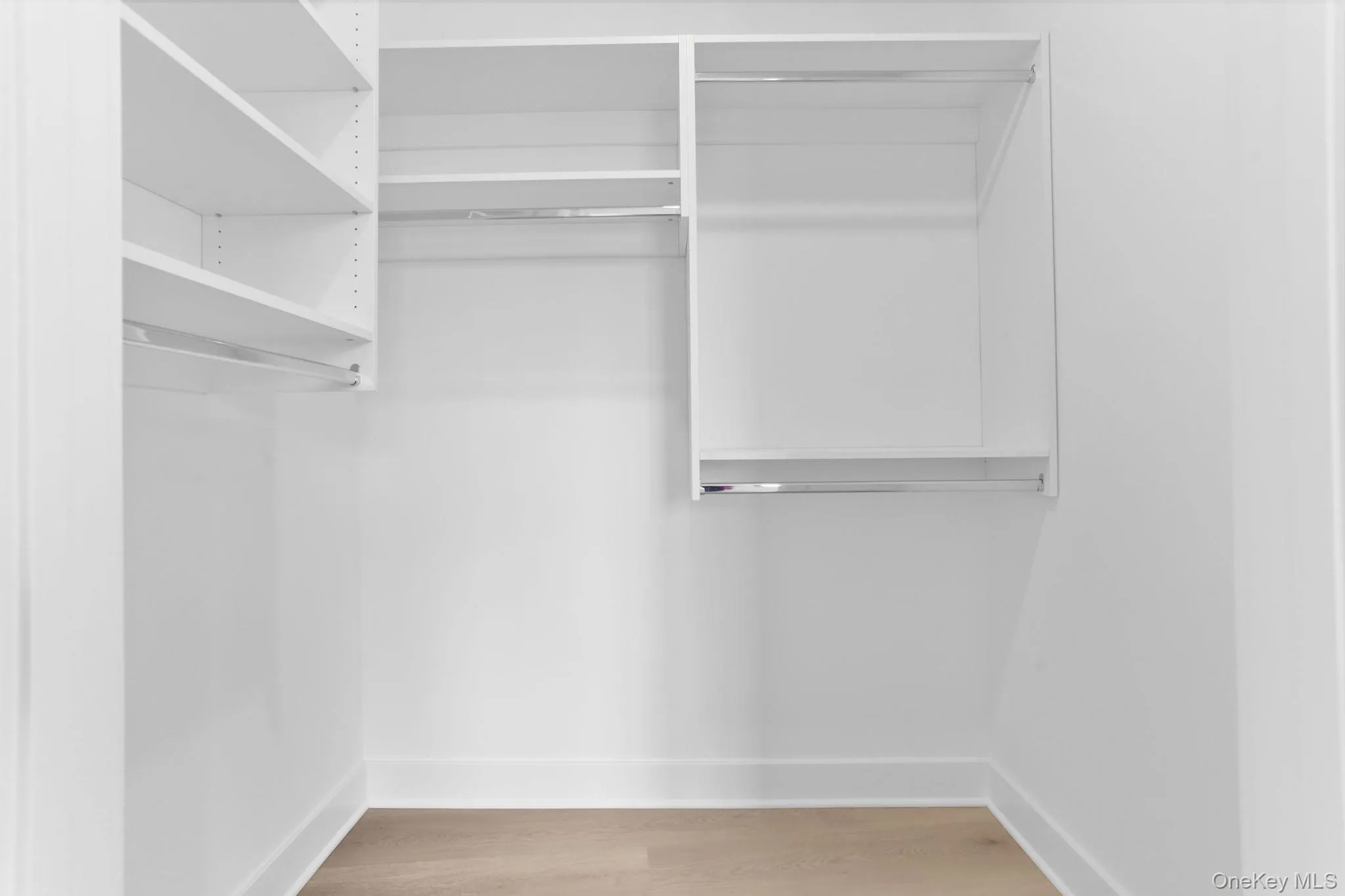 Walk in closet with light wood-style flooring Walk in closet with light wood-style flooring