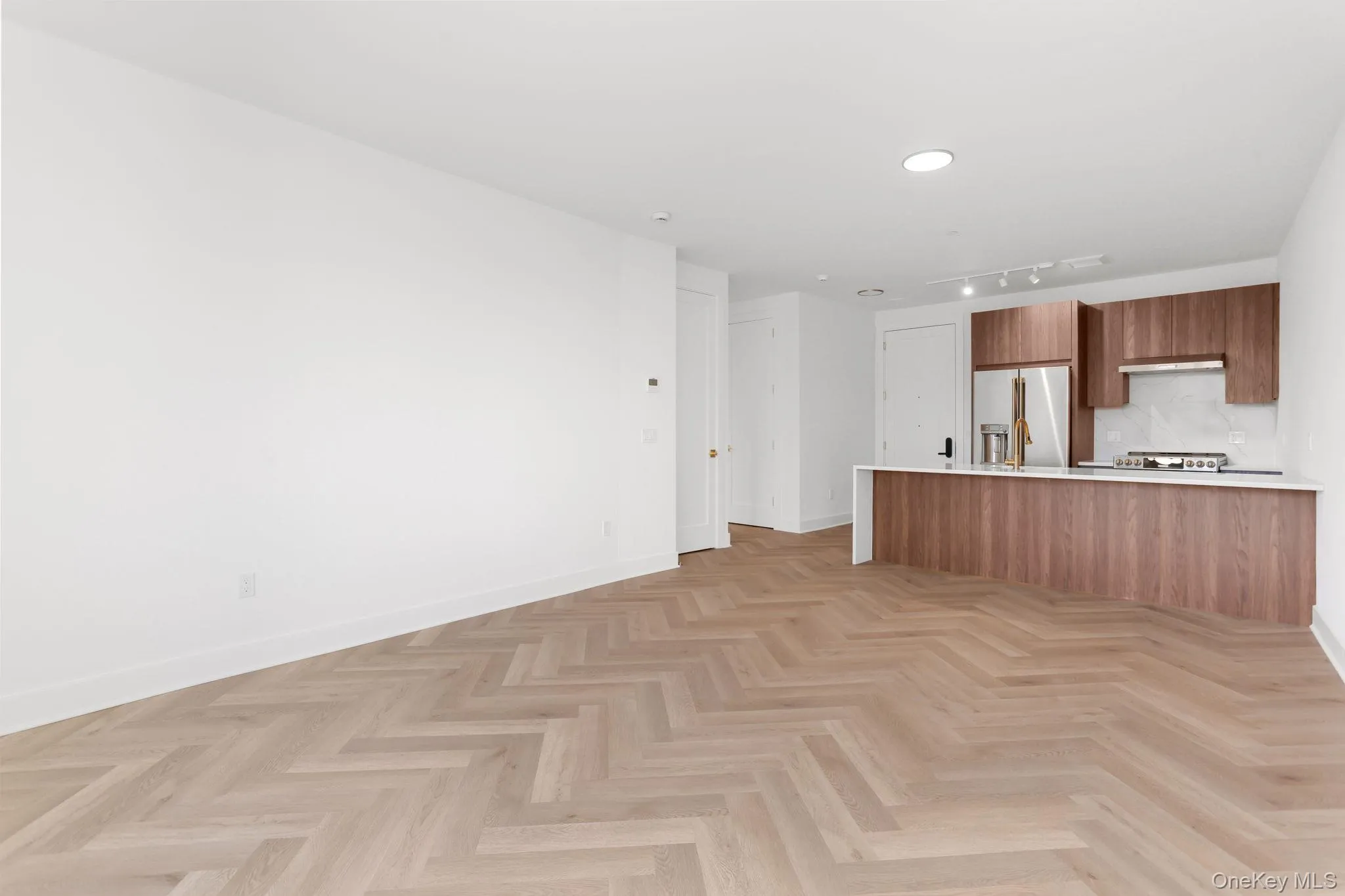 Kitchen with modern cabinets, brown cabinets, open floor plan, and high end fridge Kitchen with modern cabinets, brown cabinets, open floor plan, and high end fridge