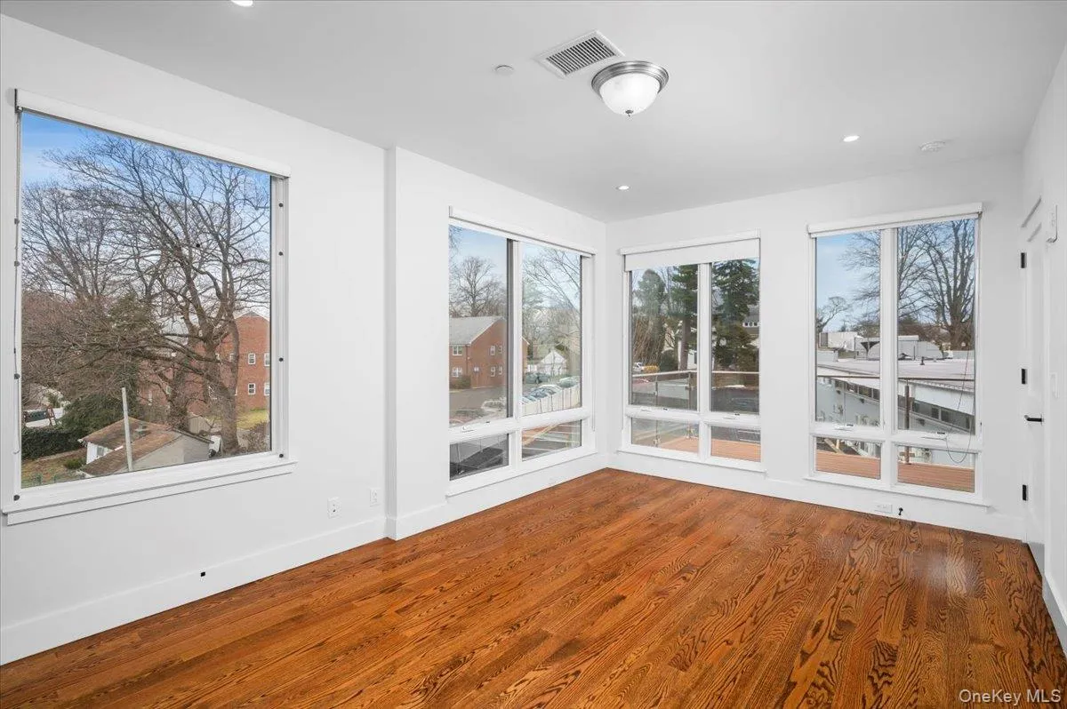 Unfurnished sunroom with wood finished floors and recessed lighting Unfurnished sunroom with wood finished floors and recessed lighting