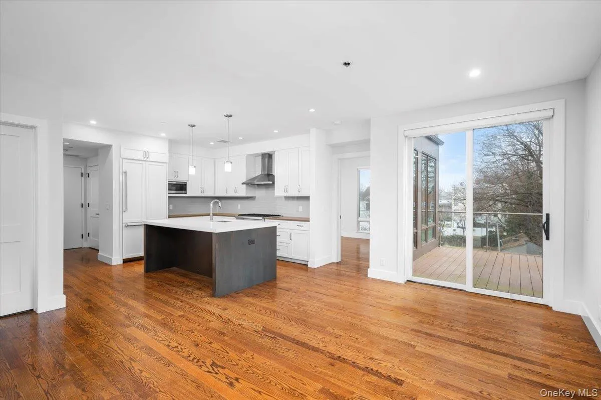Kitchen with white cabinets, a kitchen island with sink, recessed lighting, tasteful backsplash, and dark wood-style floors Kitchen with white cabinets, a kitchen island with sink, recessed lighting, tasteful backsplash, and dark wood-style floors