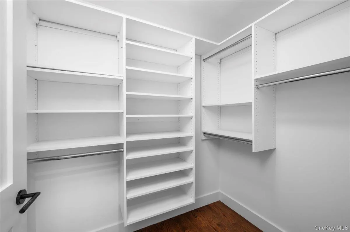 Walk in closet with dark wood-style floors Walk in closet with dark wood-style floors