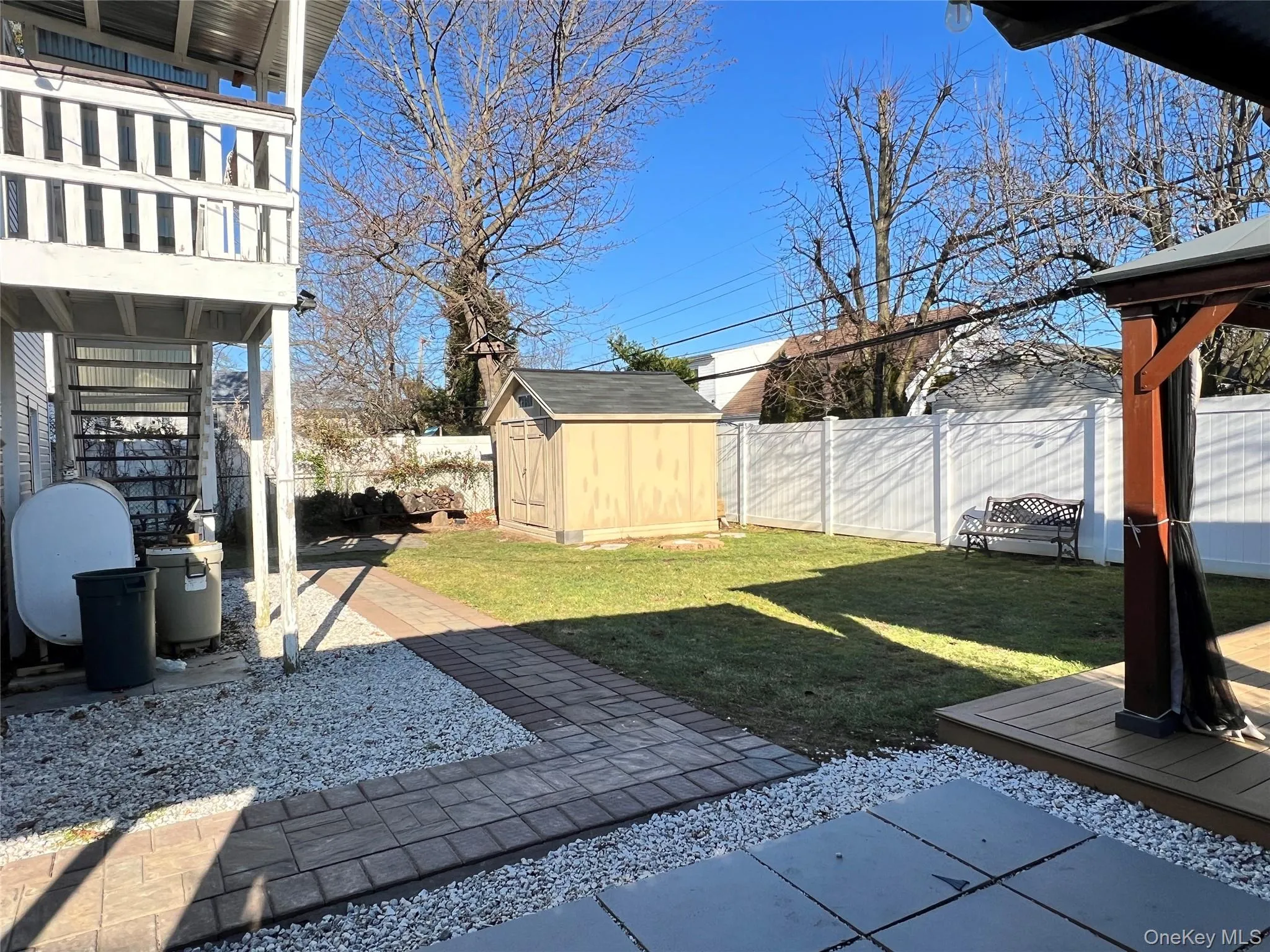 Fenced backyard with heating fuel, a shed, and a wooden deck Fenced backyard with heating fuel, a shed, and a wooden deck