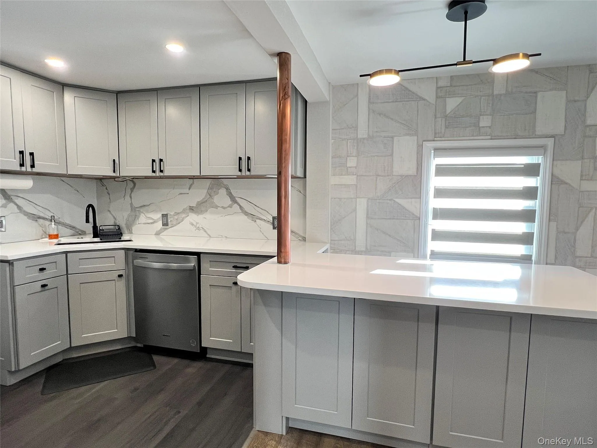 Kitchen with gray cabinetry, stainless steel dishwasher, light stone countertops, and dark wood-type flooring Kitchen with gray cabinetry, stainless steel dishwasher, light stone countertops, and dark wood-type flooring