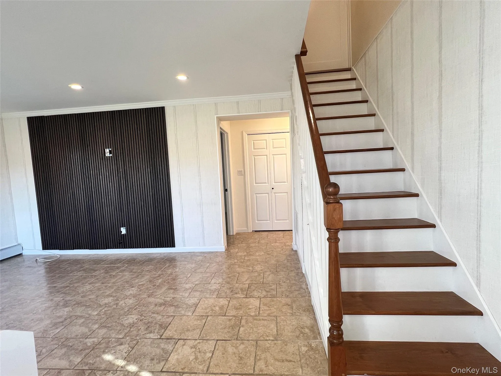 Stairs featuring stone finish floors, crown molding, and recessed lighting Stairs featuring stone finish floors, crown molding, and recessed lighting