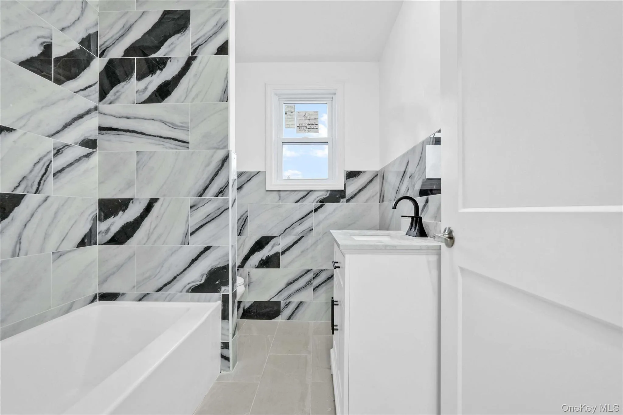 Full bathroom with vanity, tile walls, and wainscoting Full bathroom with vanity, tile walls, and wainscoting
