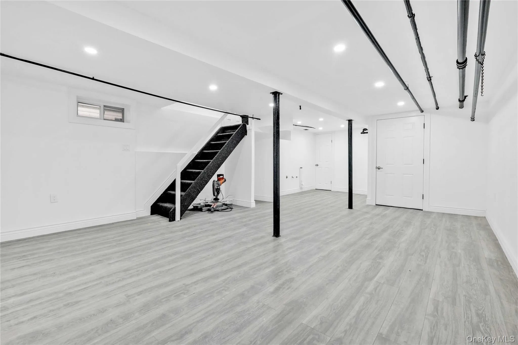 Finished basement featuring stairway, light wood finished floors, and recessed lighting Finished basement featuring stairway, light wood finished floors, and recessed lighting