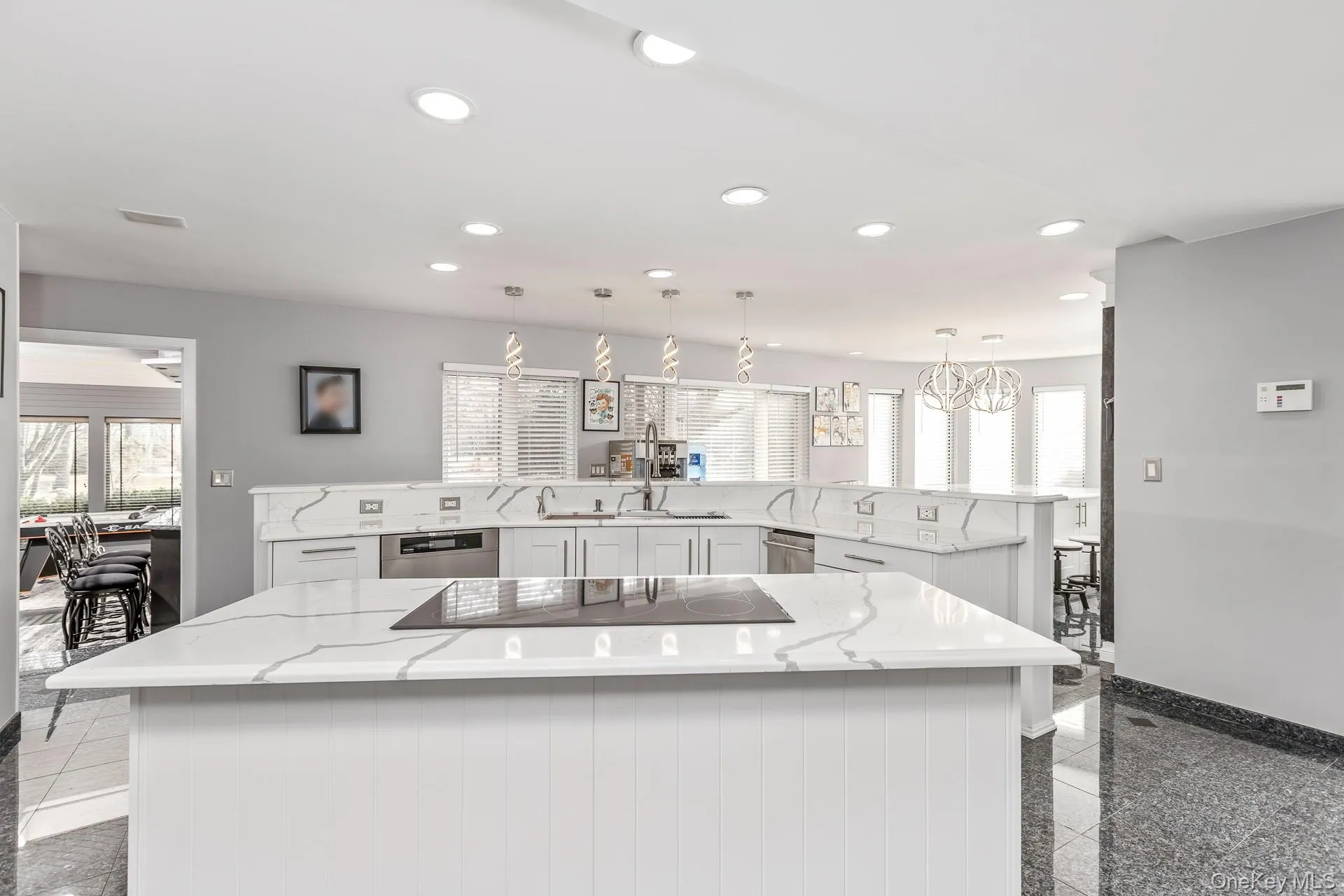 Kitchen featuring granite tiled floors, recessed lighting, decorative light fixtures, and white cabinetry Kitchen featuring granite tiled floors, recessed lighting, decorative light fixtures, and white cabinetry