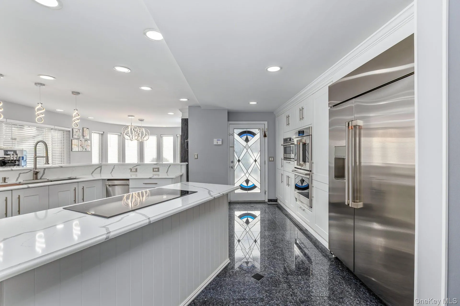 Kitchen featuring granite tiled floors, stainless steel appliances, light stone counters, white cabinets, and recessed lighting Kitchen featuring granite tiled floors, stainless steel appliances, light stone counters, white cabinets, and recessed lighting