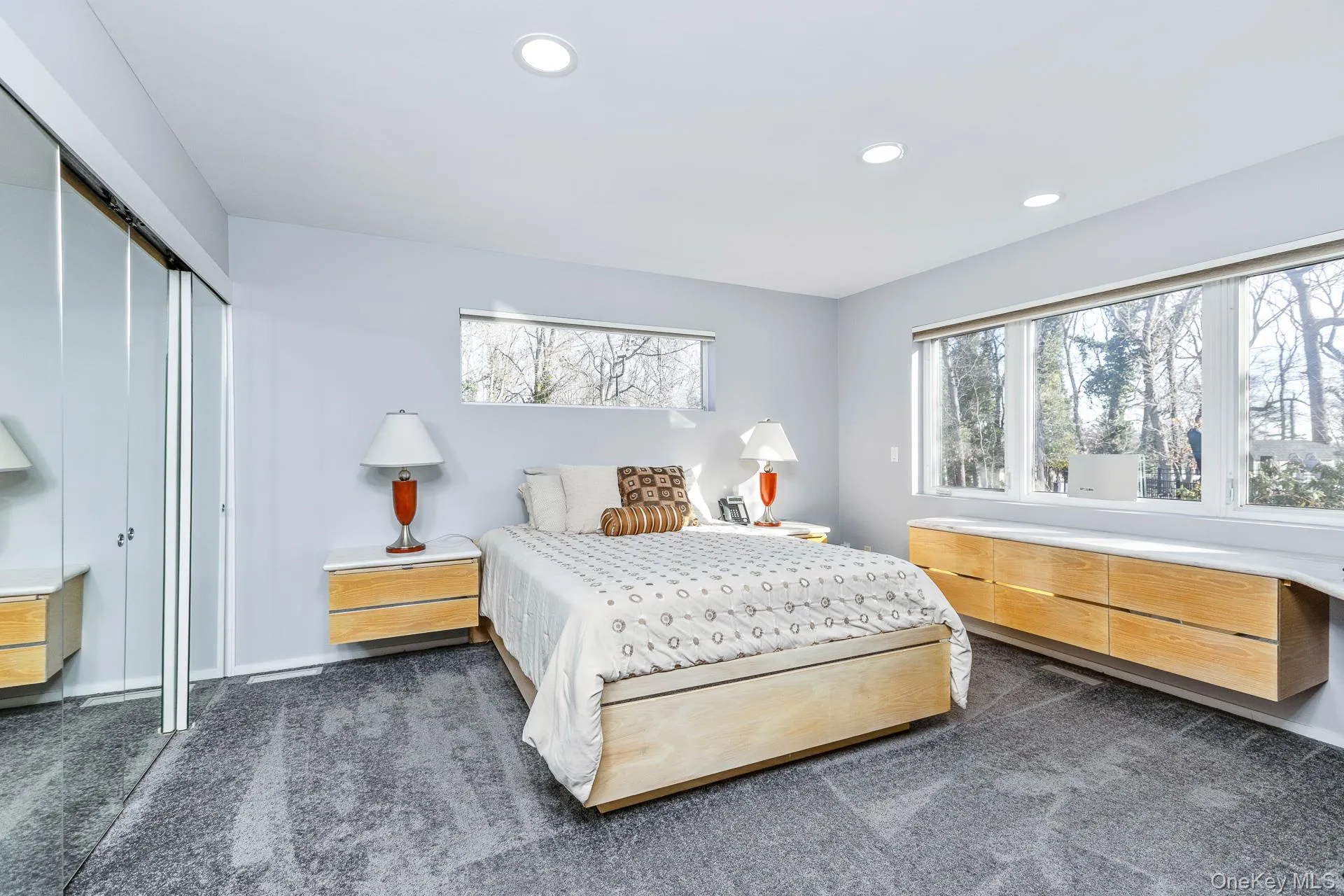Bedroom featuring dark colored carpet, multiple windows, recessed lighting, and a closet Bedroom featuring dark colored carpet, multiple windows, recessed lighting, and a closet