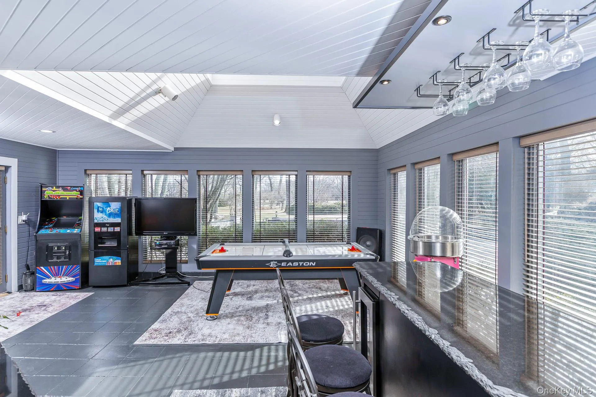 Playroom with lofted ceiling, plenty of natural light, wooden walls, wine cooler, and wooden ceiling Playroom with lofted ceiling, plenty of natural light, wooden walls, wine cooler, and wooden ceiling