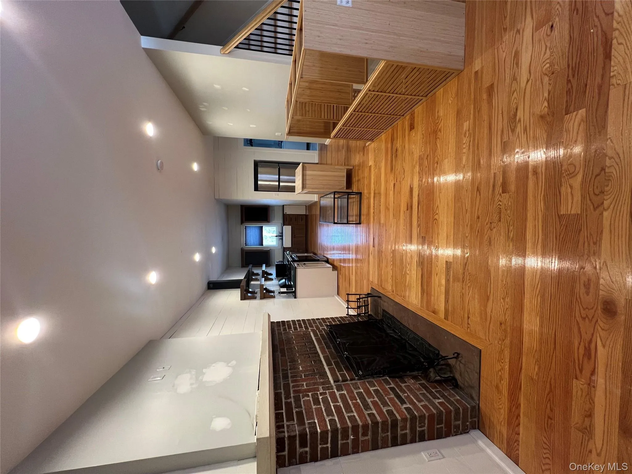 Living room with light wood finished floors, a brick fireplace, and recessed lighting Living room with light wood finished floors, a brick fireplace, and recessed lighting