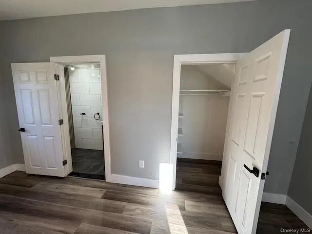 Unfurnished bedroom featuring ensuite bath, and a walk in closet. Unfurnished bedroom featuring ensuite bath, and a walk in closet.