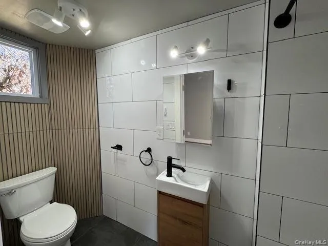 Half bath with vanity and tile walls Half bath with vanity and tile walls