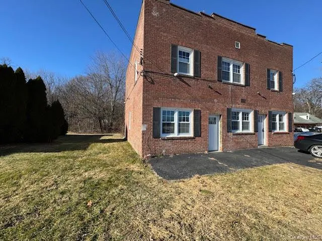 View of front facade with brick siding and a front yard View of front facade with brick siding and a front yard