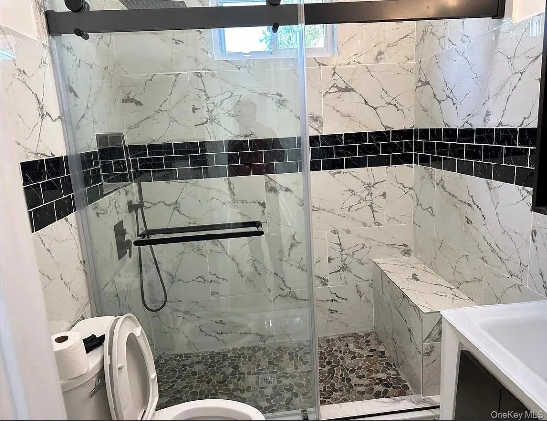 Bathroom with a marble finish shower and vanity Bathroom with a marble finish shower and vanity