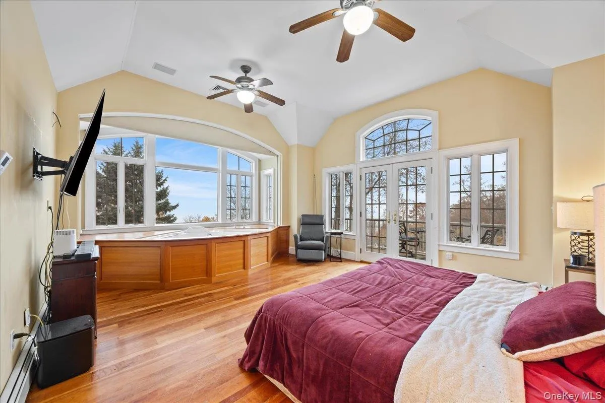 Primary Bedroom with vaulted ceiling, hardwood flooring, jacuzzi, river views and balcony Primary Bedroom with vaulted ceiling, hardwood flooring, jacuzzi, river views and balcony