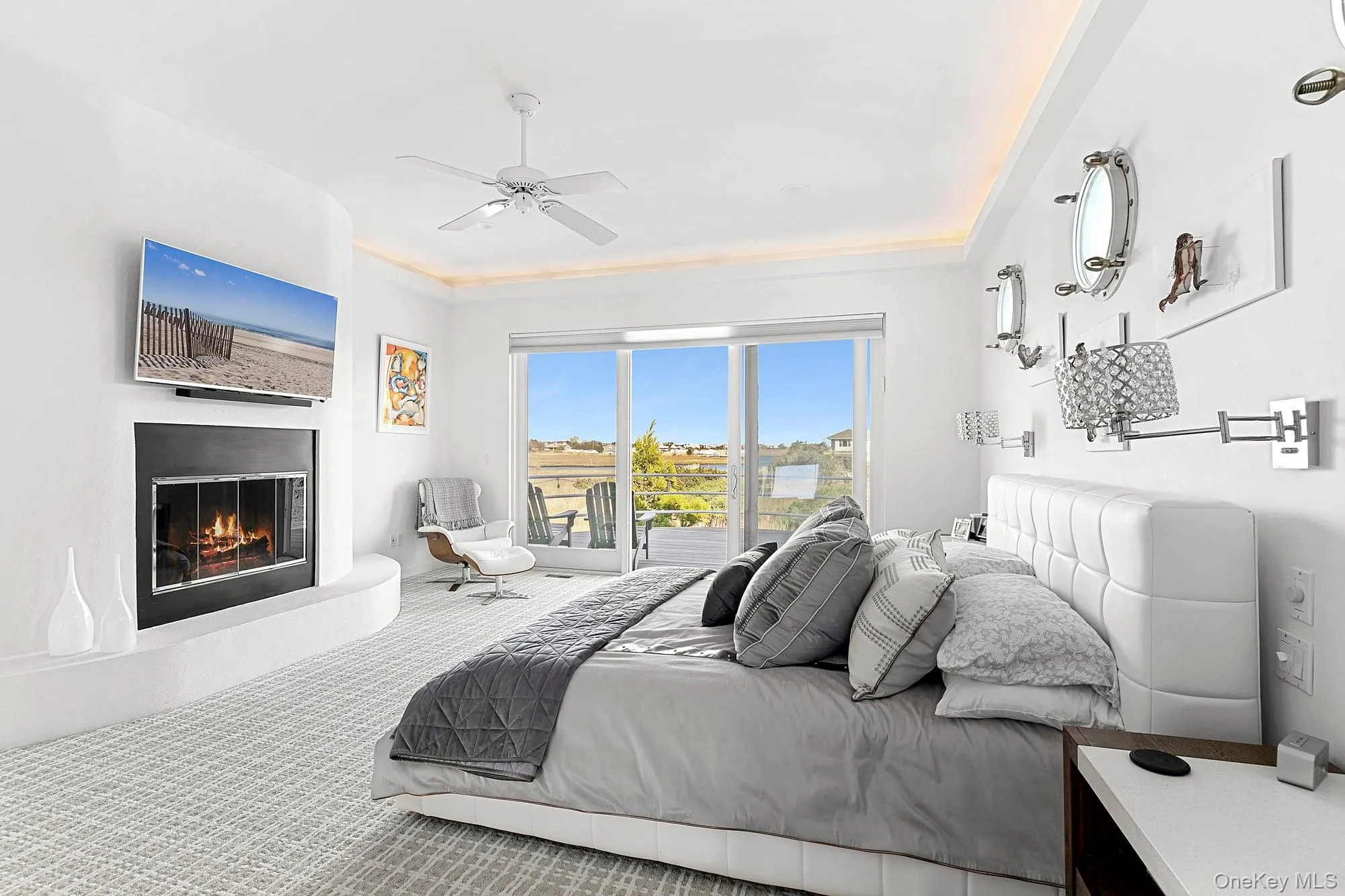 Bedroom featuring access to outside, a ceiling fan, carpet flooring, and a glass covered fireplace Bedroom featuring access to outside, a ceiling fan, carpet flooring, and a glass covered fireplace