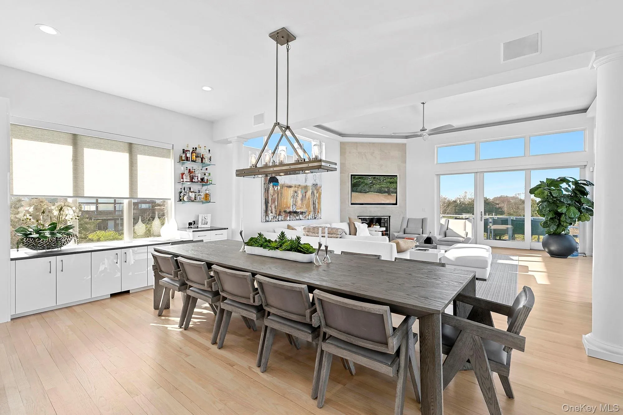 Dining space featuring light wood-style flooring, a tile fireplace, plenty of natural light, and recessed lighting Dining space featuring light wood-style flooring, a tile fireplace, plenty of natural light, and recessed lighting