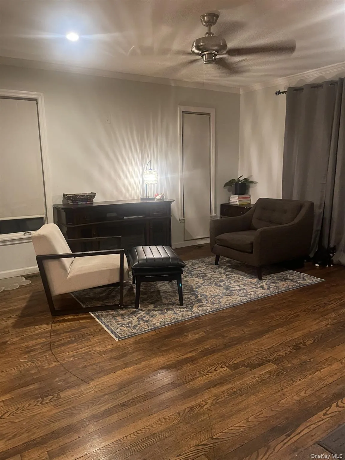 Sitting room featuring dark wood finished floors and a ceiling fan Sitting room featuring dark wood finished floors and a ceiling fan