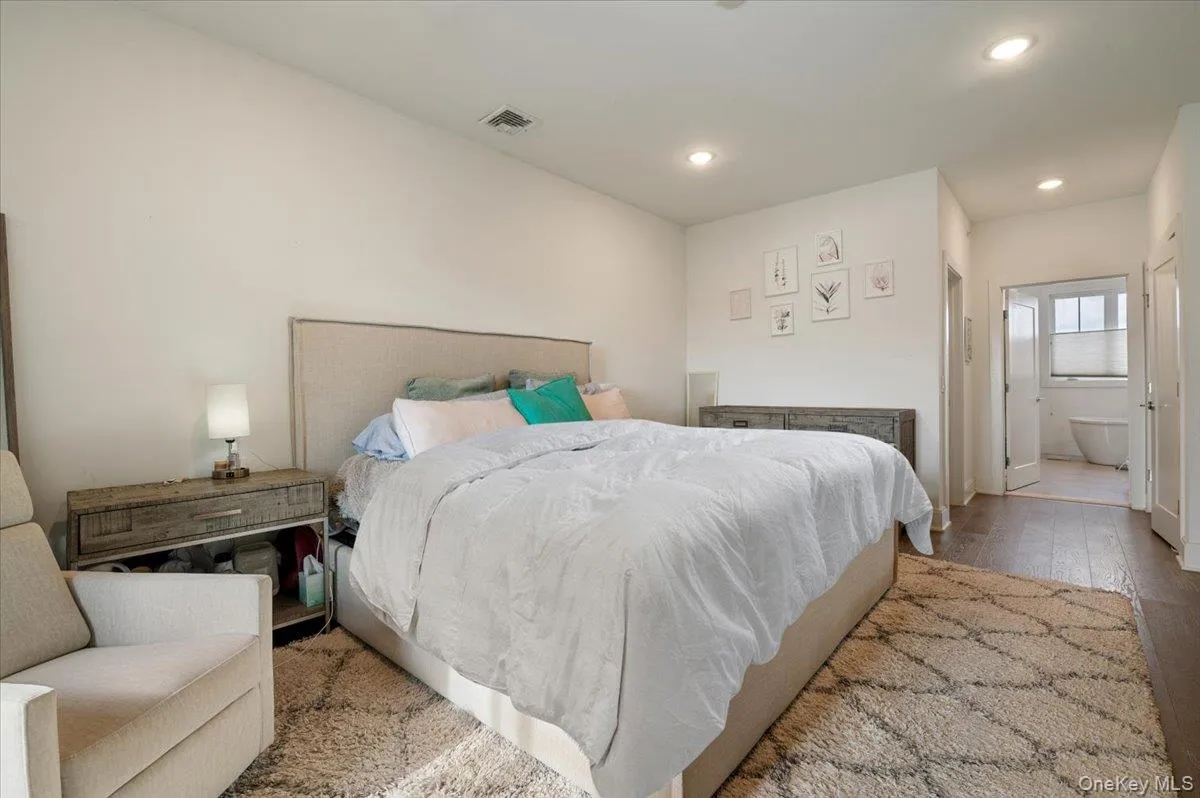 Bedroom with hardwood / wood-style floors, recessed lighting, and ensuite bathroom Bedroom with hardwood / wood-style floors, recessed lighting, and ensuite bathroom