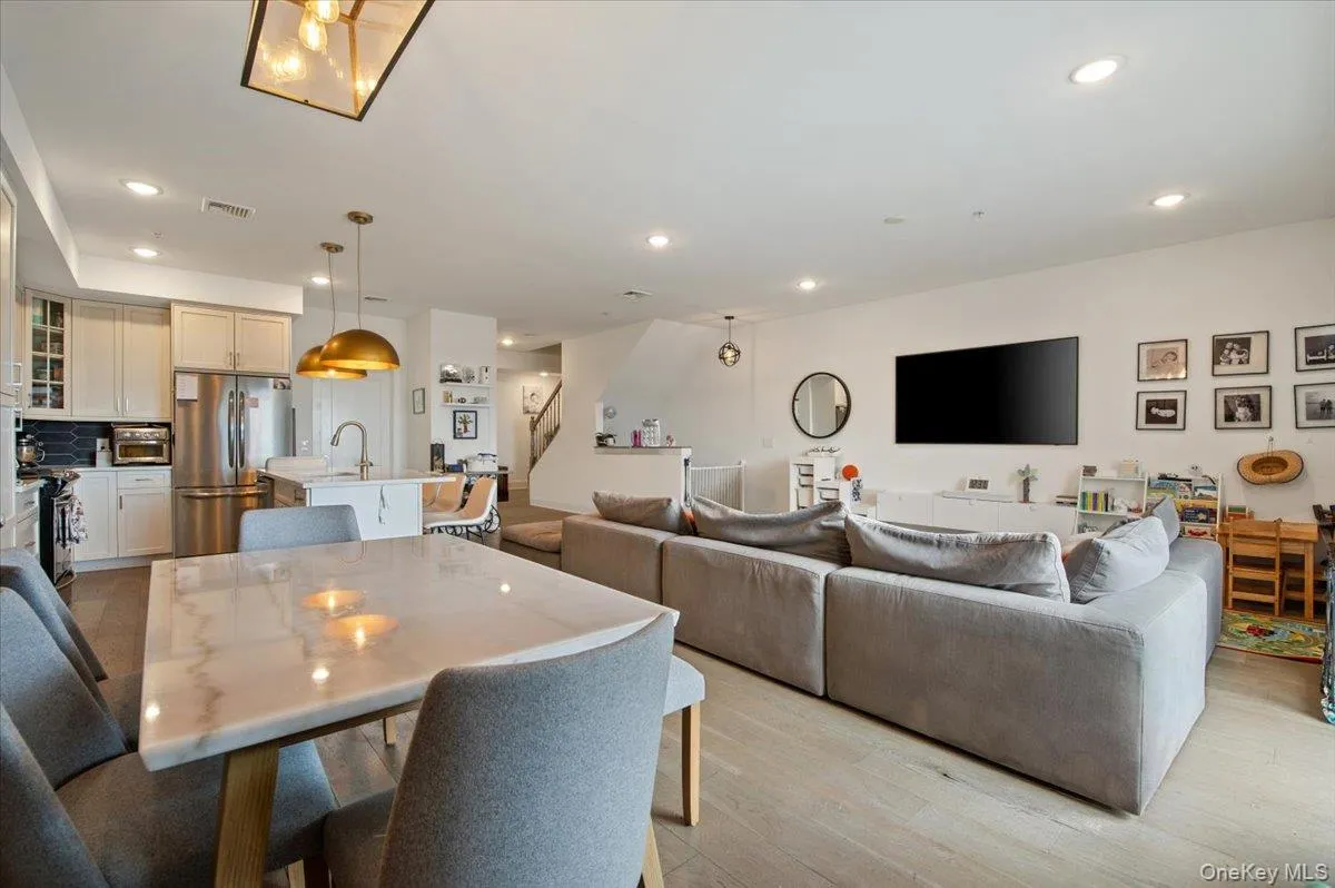 Dining area featuring light wood-style flooring, recessed lighting, and stairs Dining area featuring light wood-style flooring, recessed lighting, and stairs