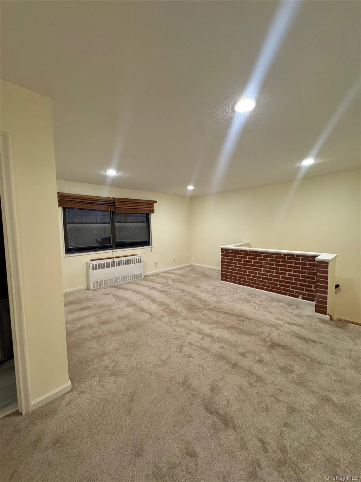 Finished basement featuring radiator, carpet flooring, and recessed lighting Finished basement featuring radiator, carpet flooring, and recessed lighting