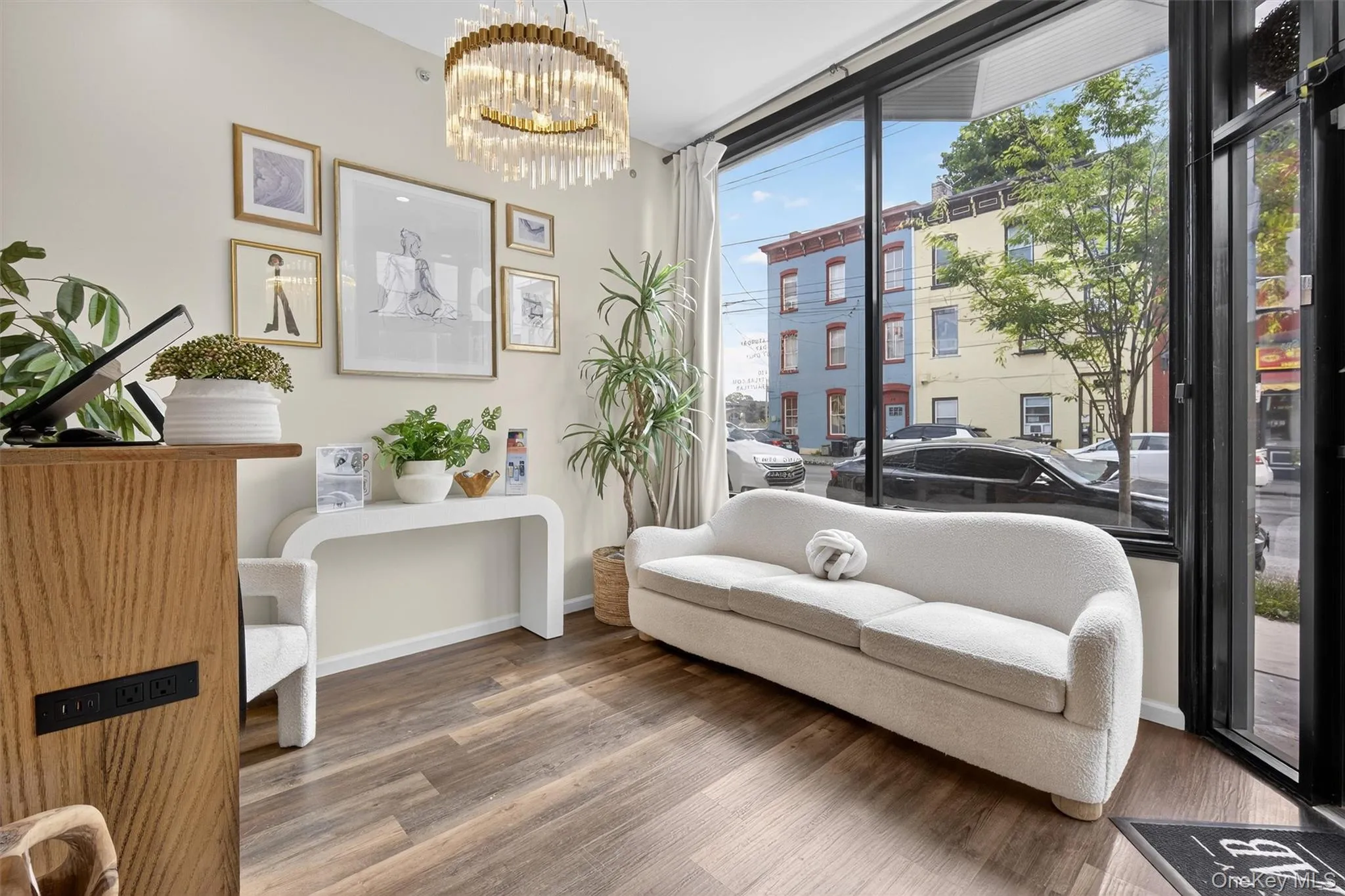 Sitting room with wood finished floors, healthy amount of natural light, a chandelier, and expansive windows Sitting room with wood finished floors, healthy amount of natural light, a chandelier, and expansive windows