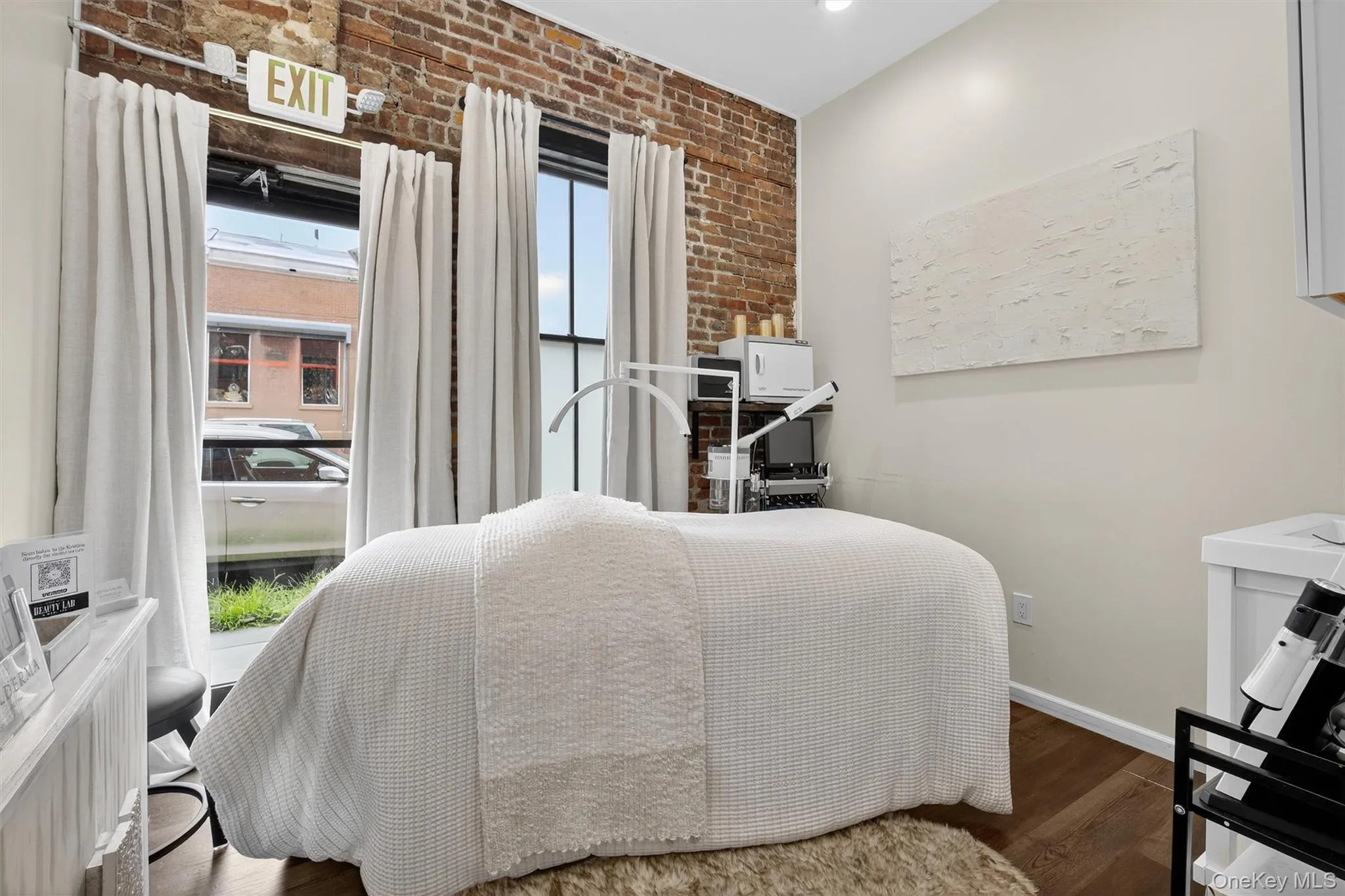 Bedroom with brick wall and dark wood finished floors Bedroom with brick wall and dark wood finished floors