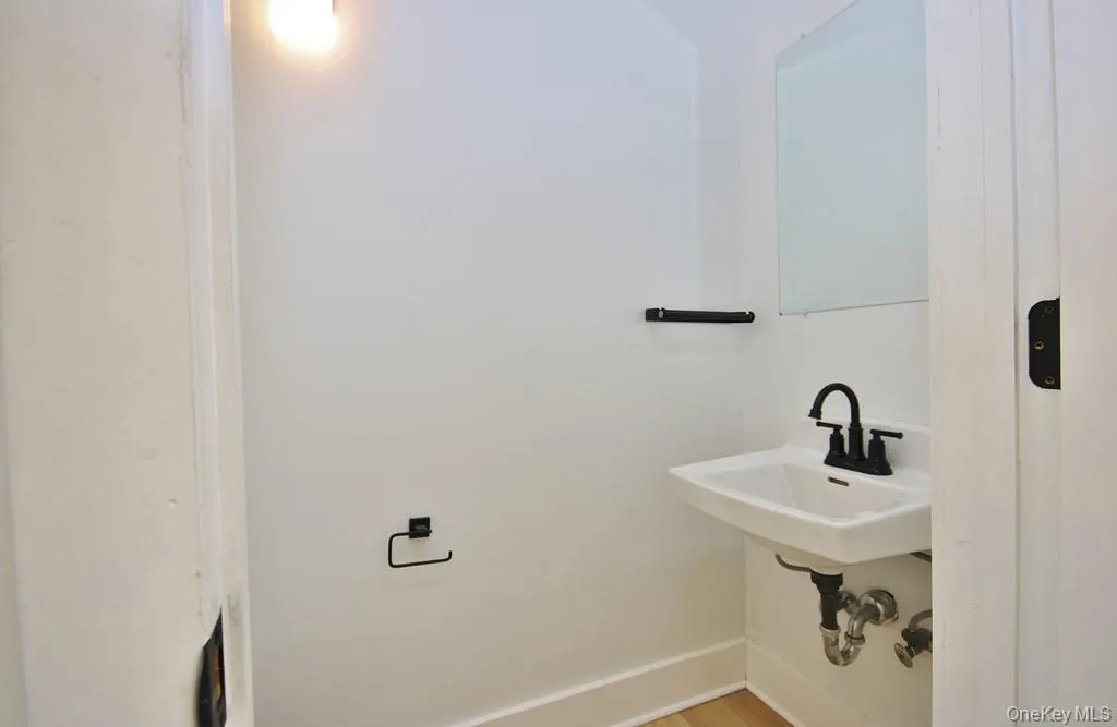 Bathroom featuring baseboards and light wood-type flooring Bathroom featuring baseboards and light wood-type flooring