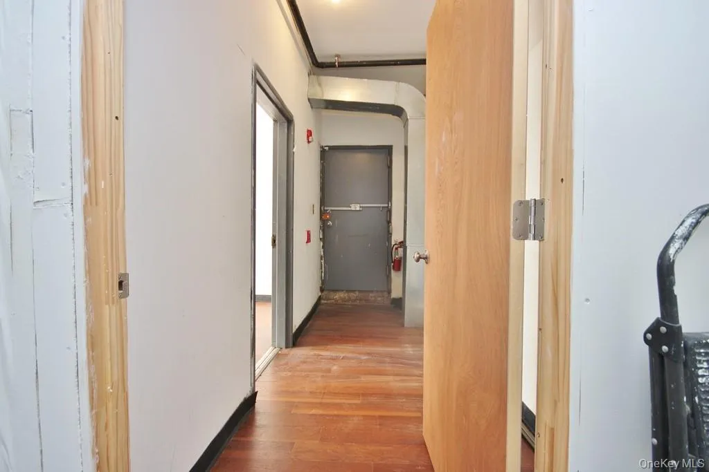 Hall featuring wood finished floors and arched walkways Hall featuring wood finished floors and arched walkways