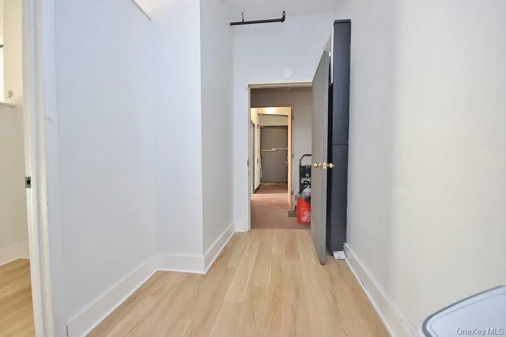 Hall with light wood-style flooring and baseboards Hall with light wood-style flooring and baseboards