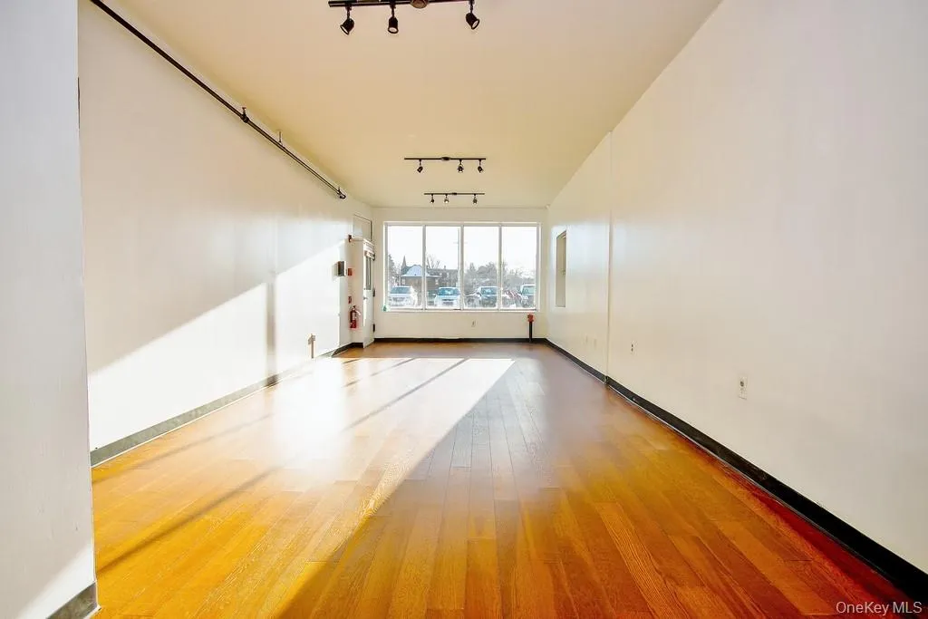 Spare room featuring hardwood / wood-style flooring and rail lighting Spare room featuring hardwood / wood-style flooring and rail lighting